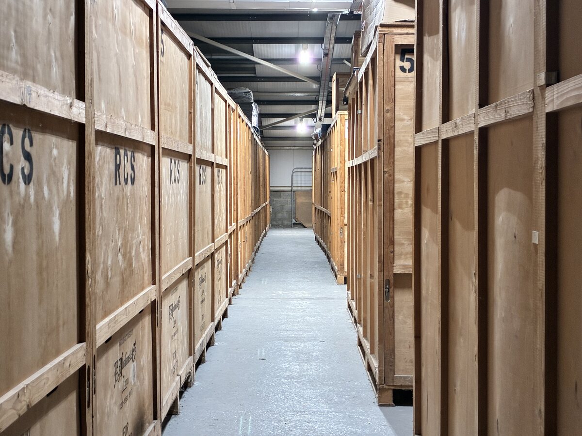 Wooden storage units lining a bright aisle inside the RCS warehouse